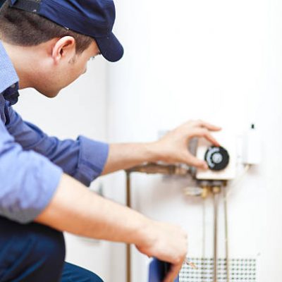 Smiling technician repairing an hot-water heater